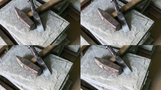 破碎瓷砖上的锤子和凿子