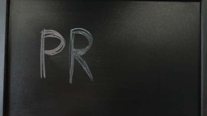 黑板上用五颜六色的粉笔写的骄傲词。男性手写骄傲在黑板上