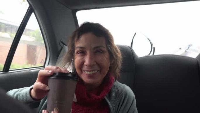 特写的老年妇女在车内的塑料杯中喝着热的稀释剂，白天在4k中惊讶地品尝和微笑