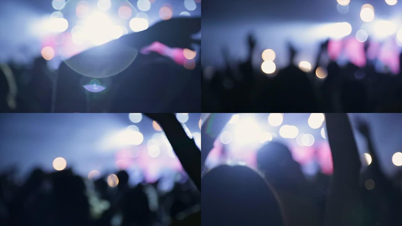 音乐会上跳舞人群的镜头模糊。观众有节奏地向音乐挥手。