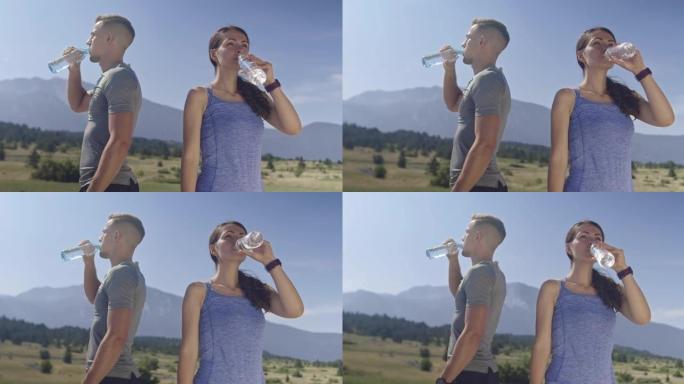 运动的年轻夫妇在跑步后喝淡水，使自己精神焕发。健康的生活方式和jpgging概念。