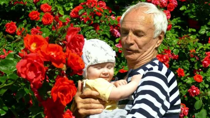 老人在玫瑰园里抱着一个婴儿玩