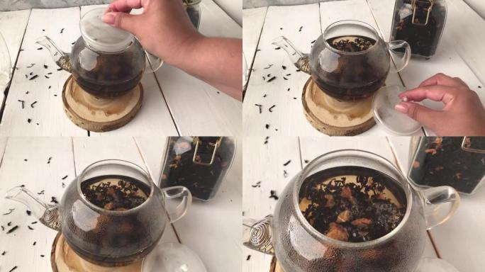 女孩手倒开水蛋羹玻璃茶壶配叶茶