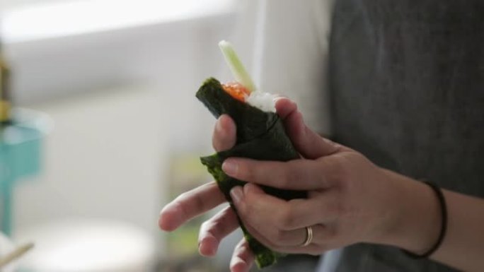日本女性视频记录器在她的虚拟烹饪课活动中制作temaki寿司卷