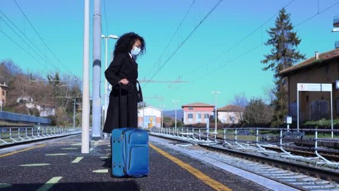 带面具旅行-带面具的西班牙裔妇女在车站等待火车