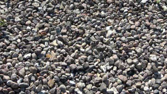 石头慢慢落在地上的砾石上。