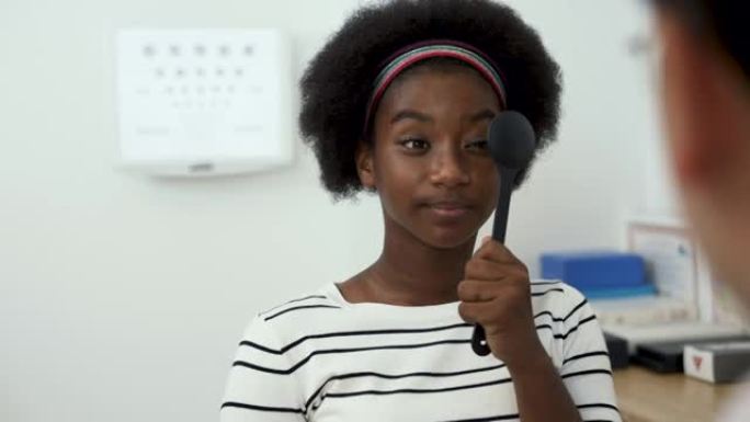 亚洲眼科医生检查非洲少女的视力。