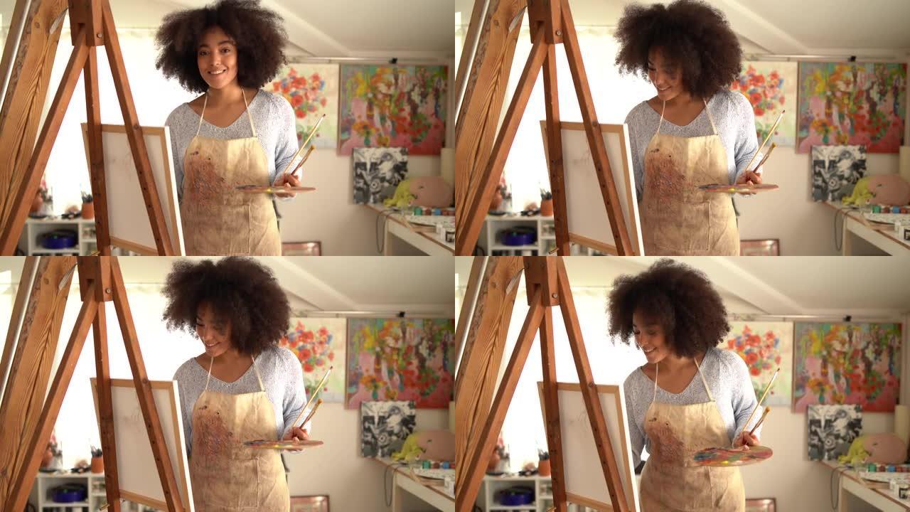 有吸引力的美国黑人女画家在艺术工作室用画笔和画架创作图片的4k视频特写