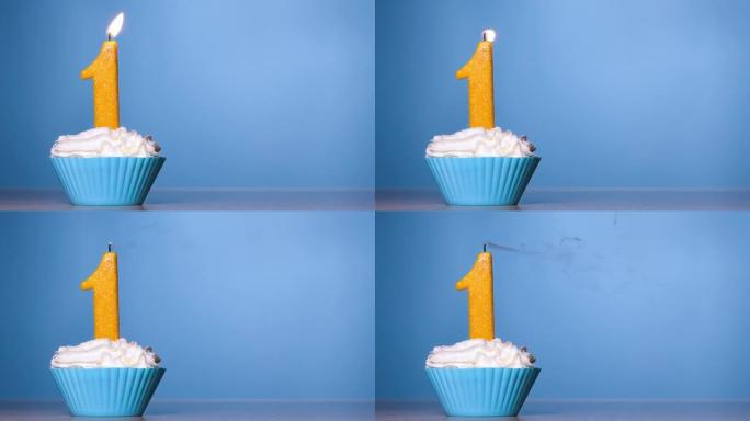 吹灭蛋糕上的蜡烛。柔和蓝色背景上燃烧的彩色蜡烛一号生日蛋糕。120 FPS。带复制空间的慢动作周年横