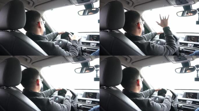 一个年轻人驾驶汽车，并在4k白天与朋友乘车旅行时挥手致意