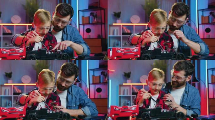 好看的满意的有爱心的成人胡子的父亲在防护眼镜上教焊接玩具车的小细节他好奇聪明的少年儿子也戴防护眼镜