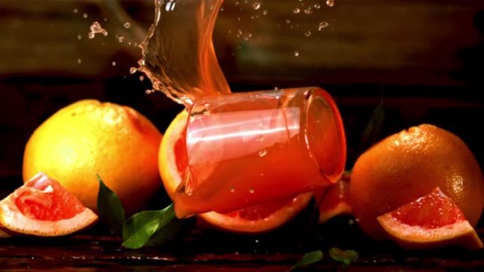 带有葡萄柚汁的超慢动作玻璃落在桌子上。以1000 fps拍摄。