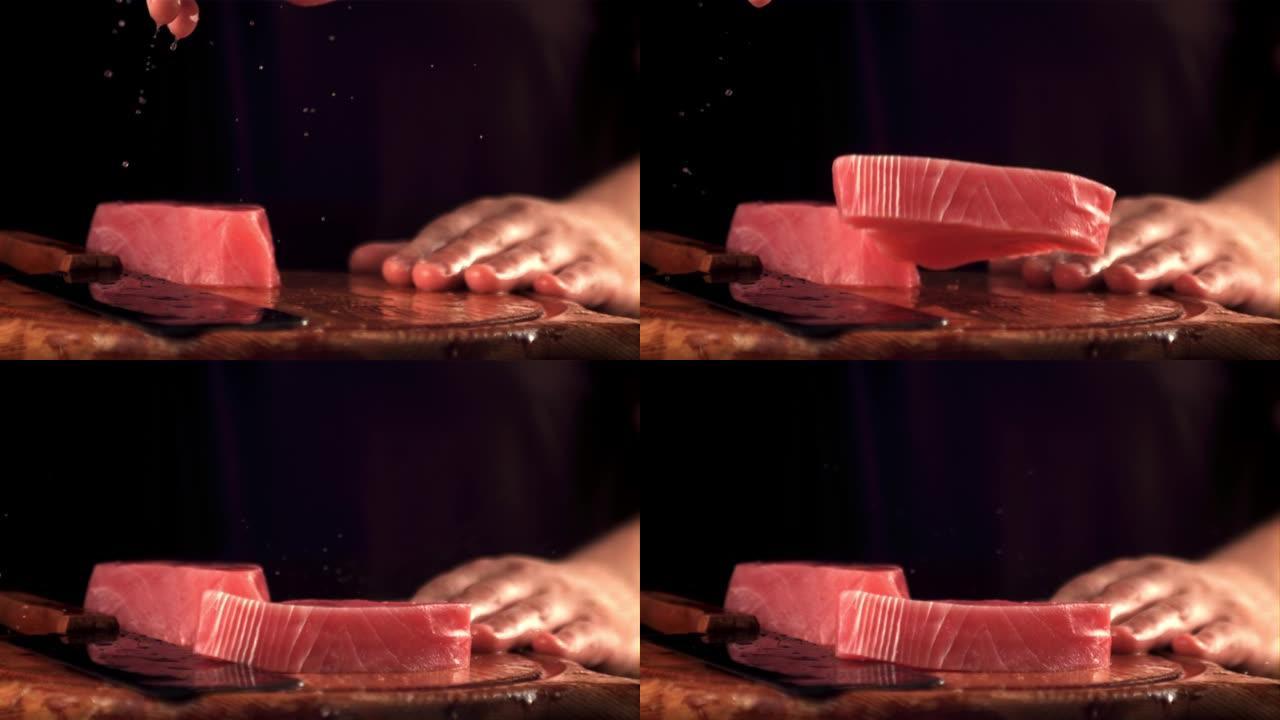 该男子的超慢动作手将生金枪鱼牛排扔在切菜板上。以1000 fps的速度在高速摄像机上拍摄。