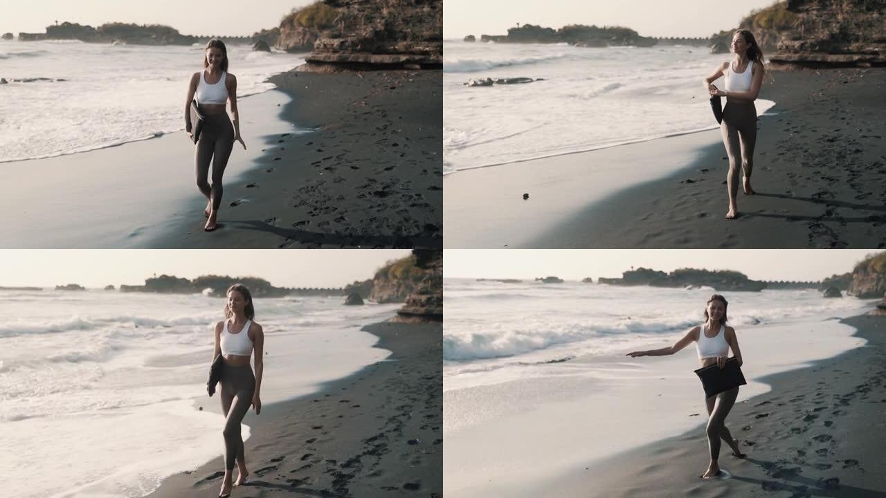穿着运动服的快乐女人沿着黑沙滩散步，微笑着转身