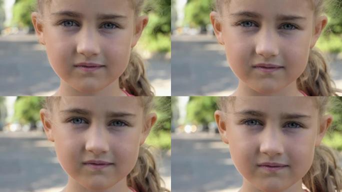 夏天，肖像小女孩站在城市的街道上看着相机。年轻认真思考好奇心的孩子在户外看相机特写。面对严肃沉思的孩