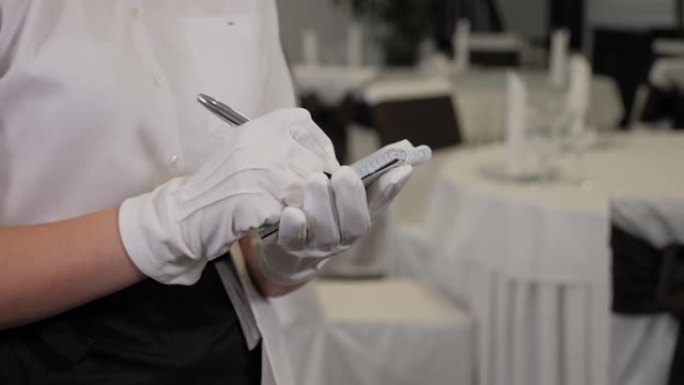 一个拿着笔记本的女服务员在一家餐馆接受顾客的订单。