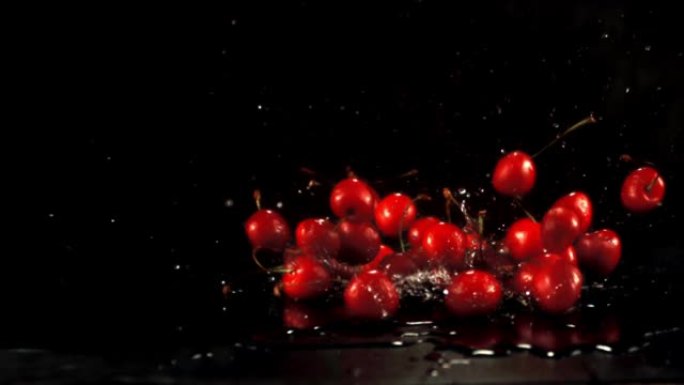 超级慢动作新鲜樱桃落在水面上飞溅。在1000 fps的高速相机上拍摄。