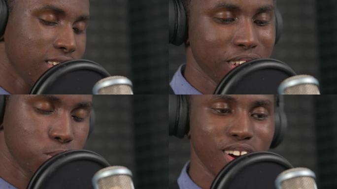非洲歌手在专业录音机工作室的耳机表演抒情歌的宏观特写镜头。背景模糊