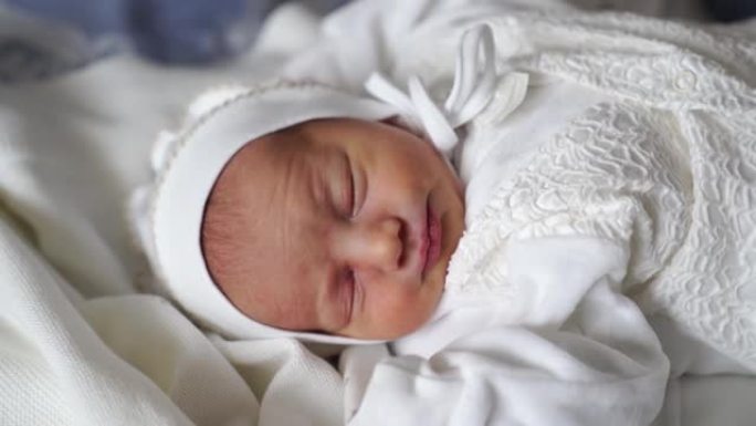 新生婴儿穿着白色衣服睡觉。出院的服装。