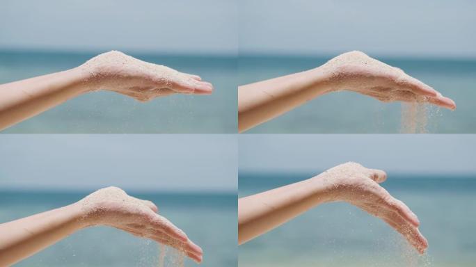 女人从手上吹沙子，沙子从手指里倒出来。沙子从手掌中张开的手的细节