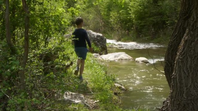 小男孩在河里扔石头