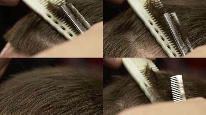 理发师用梳子和剪刀剪头发的特写镜头。