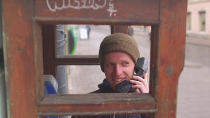 戴帽子的人在电话木制摊位电信公共场所交谈。