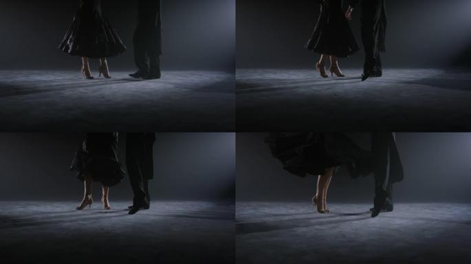 舞者的腿在地板上做动作。跳舞情侣在室内跳舞。