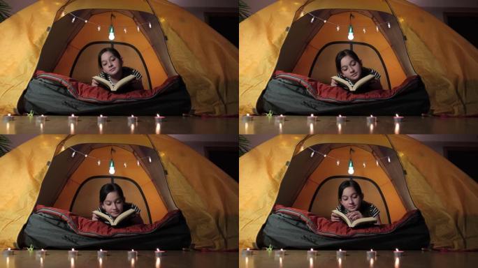 十几岁的女孩在客厅的住宿帐篷下阅读经典书籍