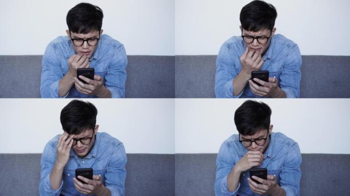 特写场景年轻的亚洲男子在阅读评论或阅读社交媒体或网站上的假新闻或智能手机上的虚假新闻时皱着眉头，对生