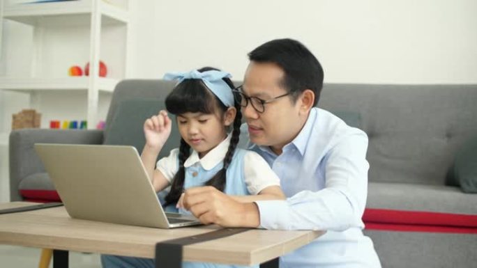 爸爸和可爱的女儿在家玩在线学习