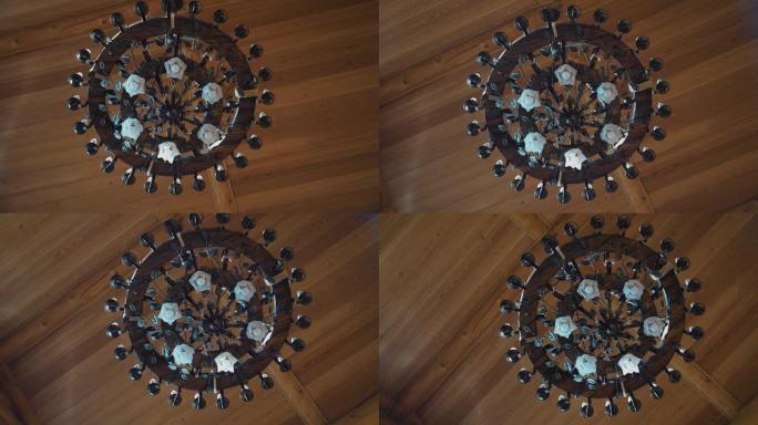 在一个木屋里，天花板上挂着一个非常漂亮的吊灯。相机旋转从下方拍摄