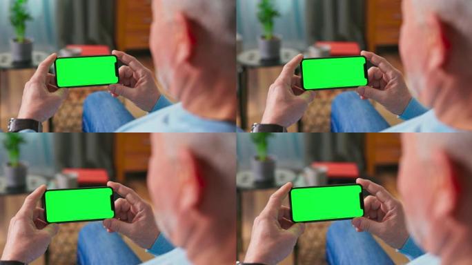 男人看系列与点播视频网站。数字智能手机的特写，带有空白的绿色模拟屏幕显示。相机即将进入平板电脑
