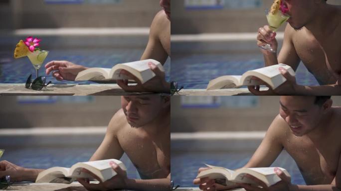 亚洲男子在游泳池酒店度假时阅读预订并喝菠萝鸡尾酒
