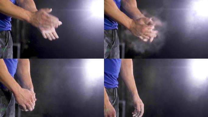 运动员手健身房粉笔覆盖手。健美运动员拍手镁粉。