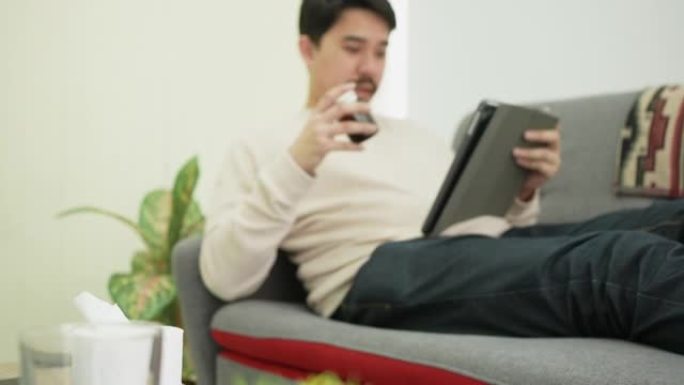 平板电脑上的成人西班牙裔男子视频流会议，与专家咨询身体疾病和药物，并在家中聆听远程医疗健康技术生活概
