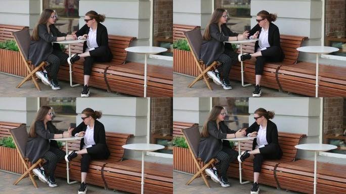 女友坐在街头咖啡馆的长椅上交流
