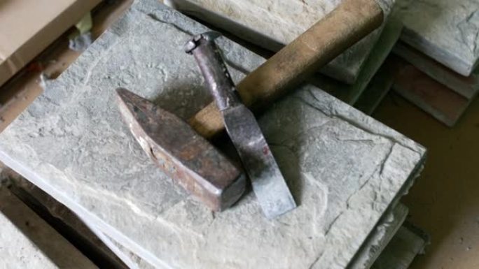 破碎瓷砖上的锤子和凿子