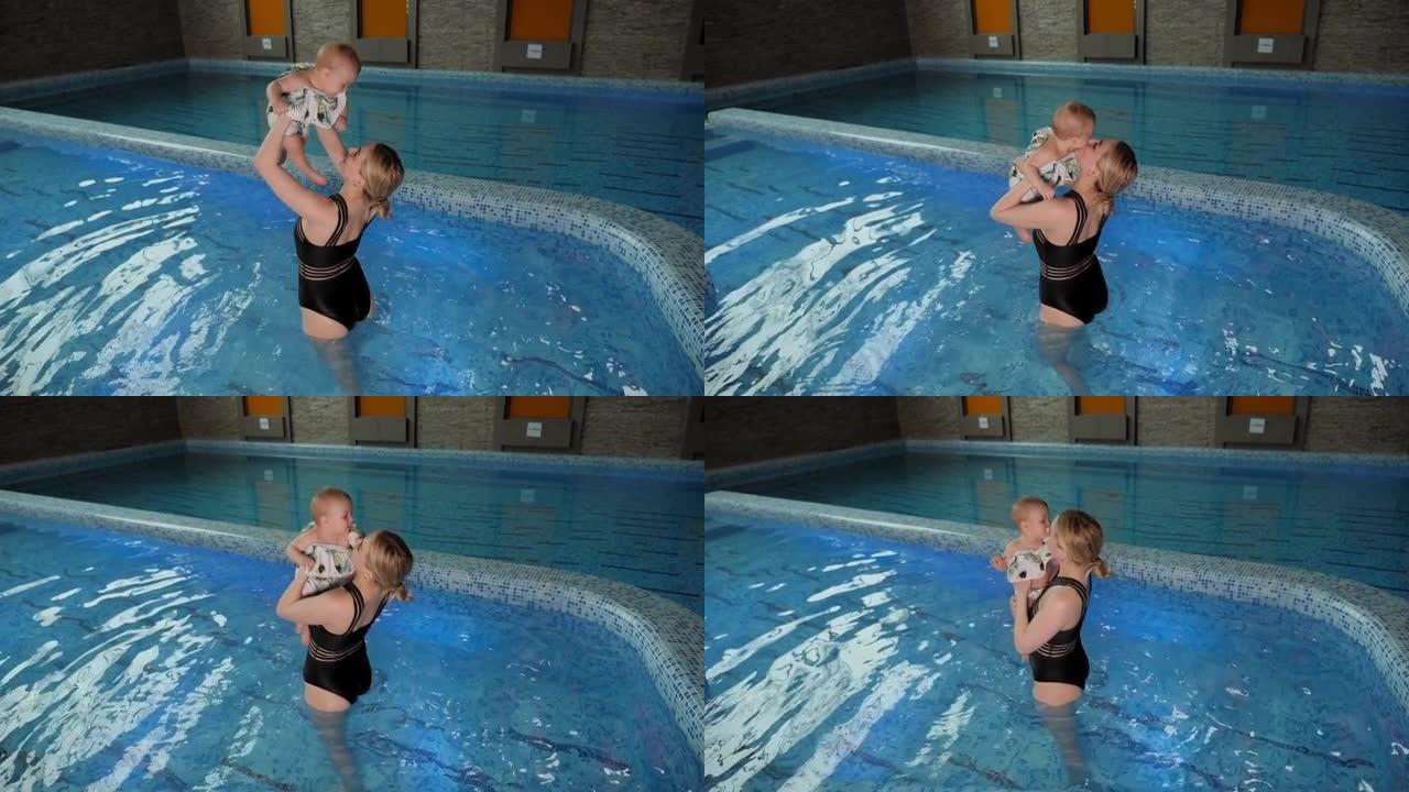 一个开朗的母亲和一个小孩在室内游泳池里玩耍。