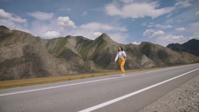 快乐的年轻女性徒步旅行。背着背包的旅行者沿着美丽地区的山路散步