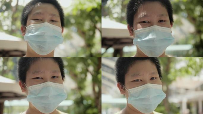 新型冠状病毒肺炎期间，亚洲儿童在户外面罩下微笑，社交疏远的生活方式理念。