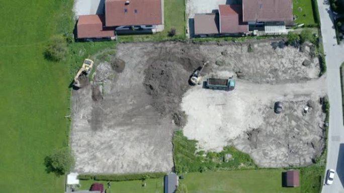 房屋建设。空中鸟景。卡车被挖掘机装满