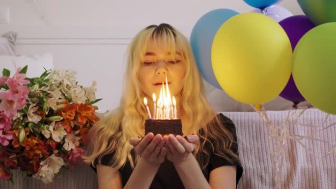女少年的生日，带生日小蛋糕的女孩，用燃烧的蜡烛，吹灭蜡烛