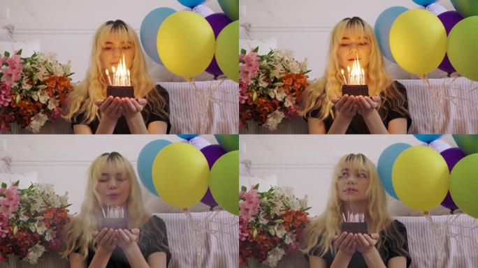 女少年的生日，带生日小蛋糕的女孩，用燃烧的蜡烛，吹灭蜡烛
