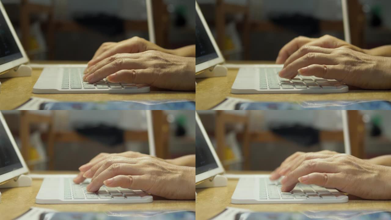 成人的双手在厨房里用无线键盘与数字平板电脑捆绑，同时在家工作，检疫生活方式的概念。