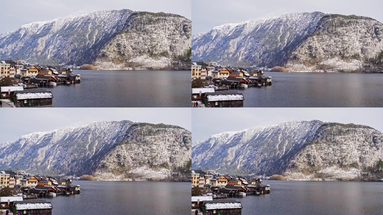 奥地利阳光明媚的冬日，美丽的哈尔施塔特小村庄，古老的木屋被安置在湖边，高高的雪山