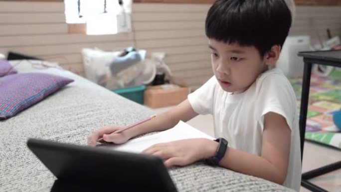 亚洲男孩在家参加在线课程。
