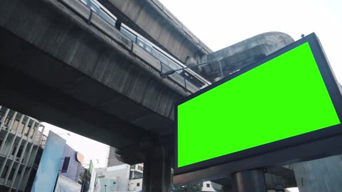 赛博朋克城市电动火车站上的空广告牌绿屏