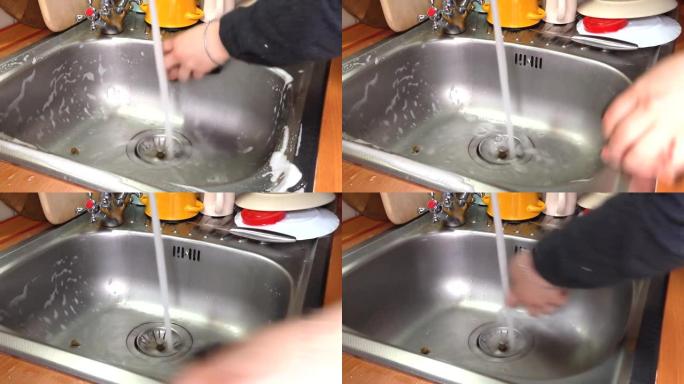女人的手清洁厨房水槽中的污垢。女孩冲洗泡沫清洁剂。家务劳动。清洁厨房和日常生活的概念