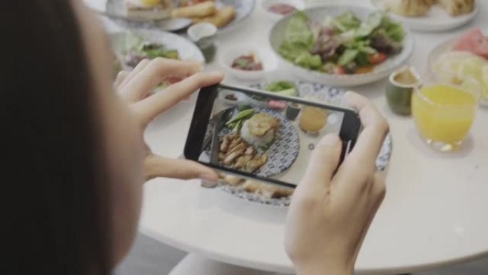 东南亚妇女为食品博客信息拍照